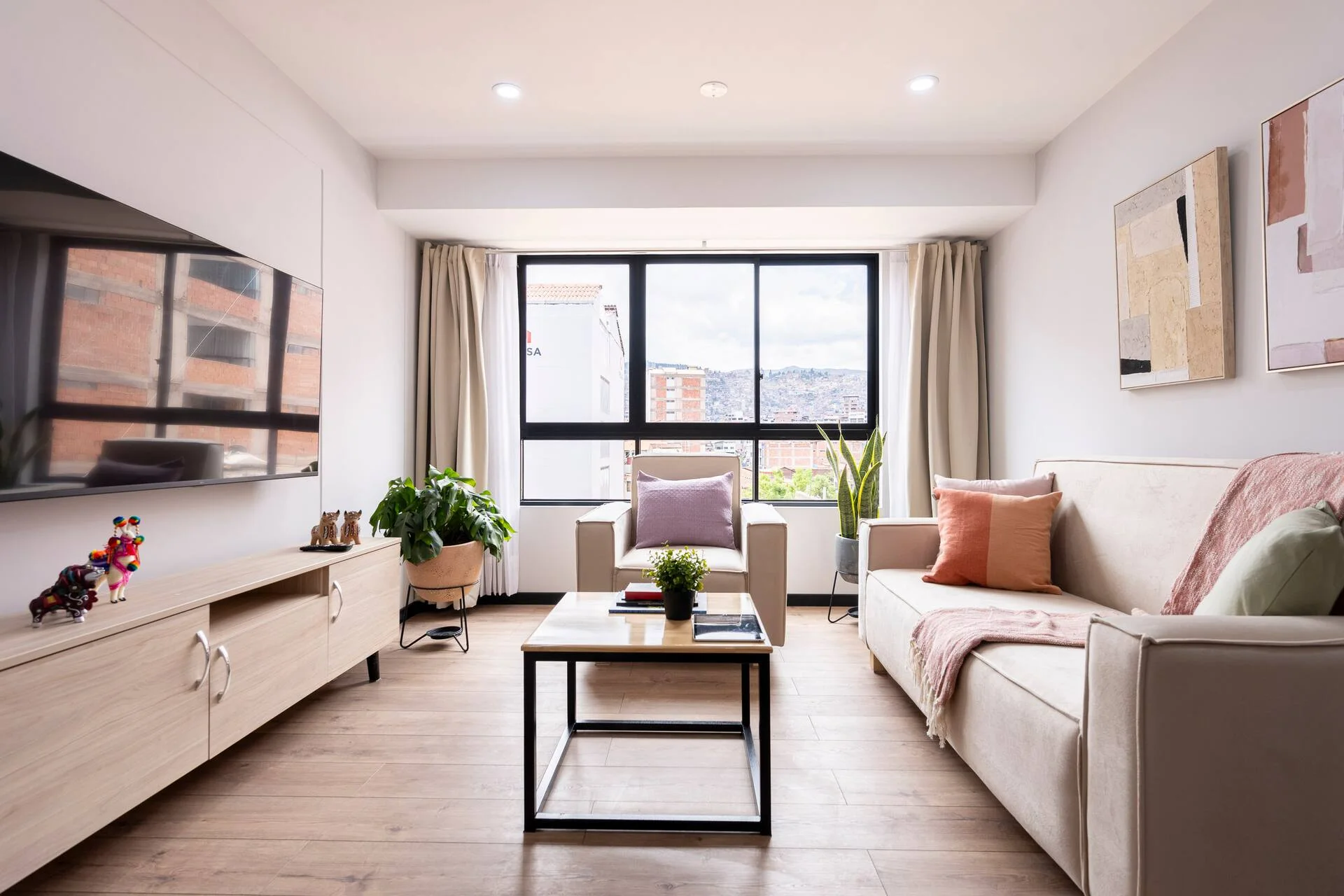 Sala luminosa con sofás claros y ventanales